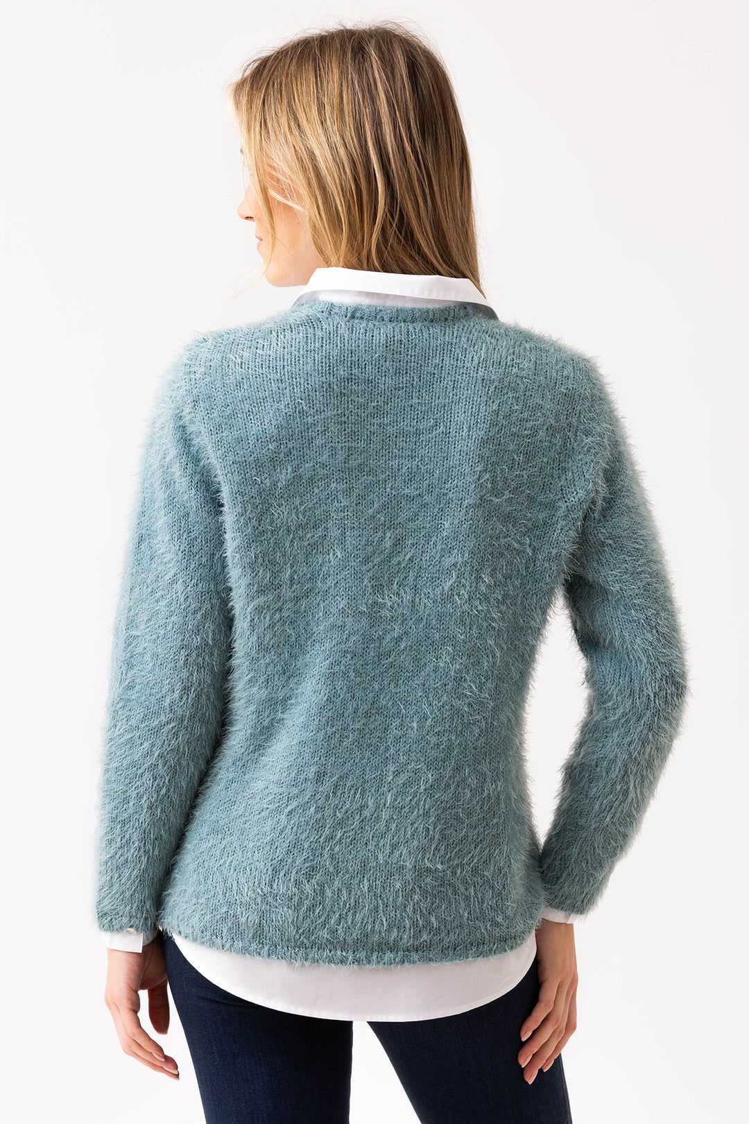 Woman wearing a teal sweater on a white background