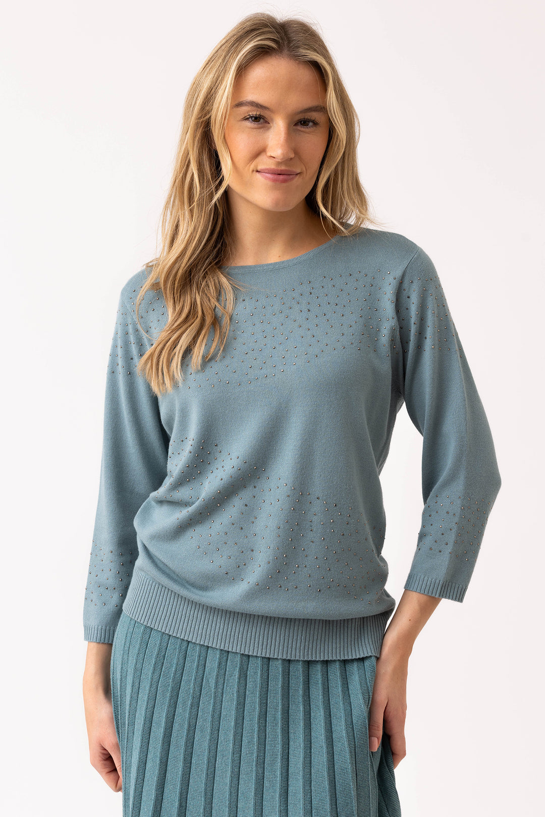 Woman wearing a light blue sweater with a plain background