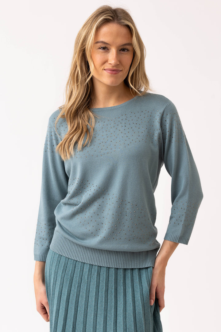 Woman wearing a light blue sweater with a plain background