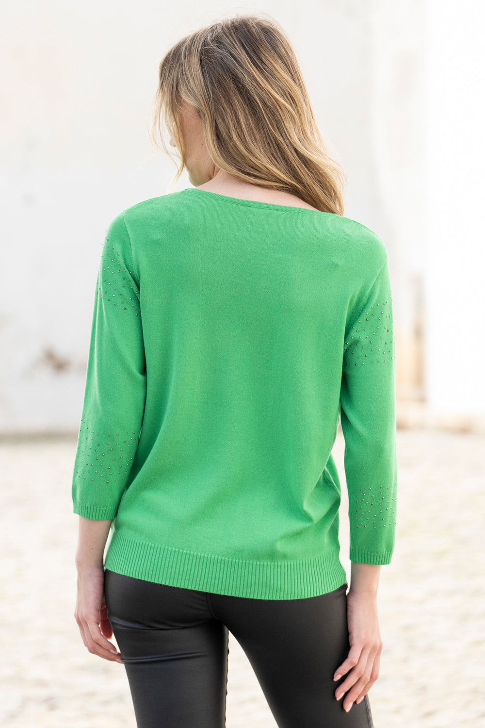 Person wearing a green sweater with a blurred background