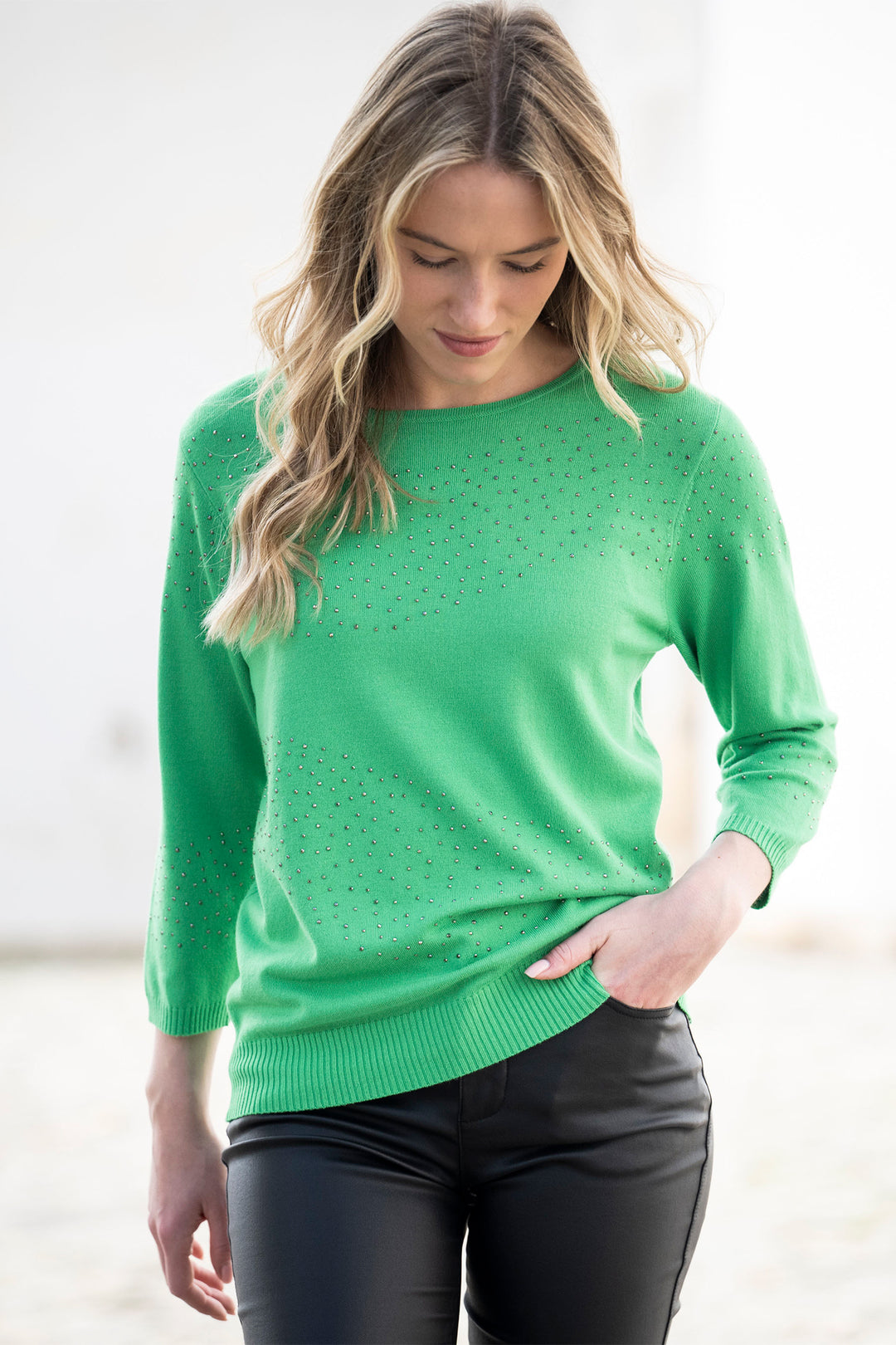 Woman wearing a green sweater with a blurred background