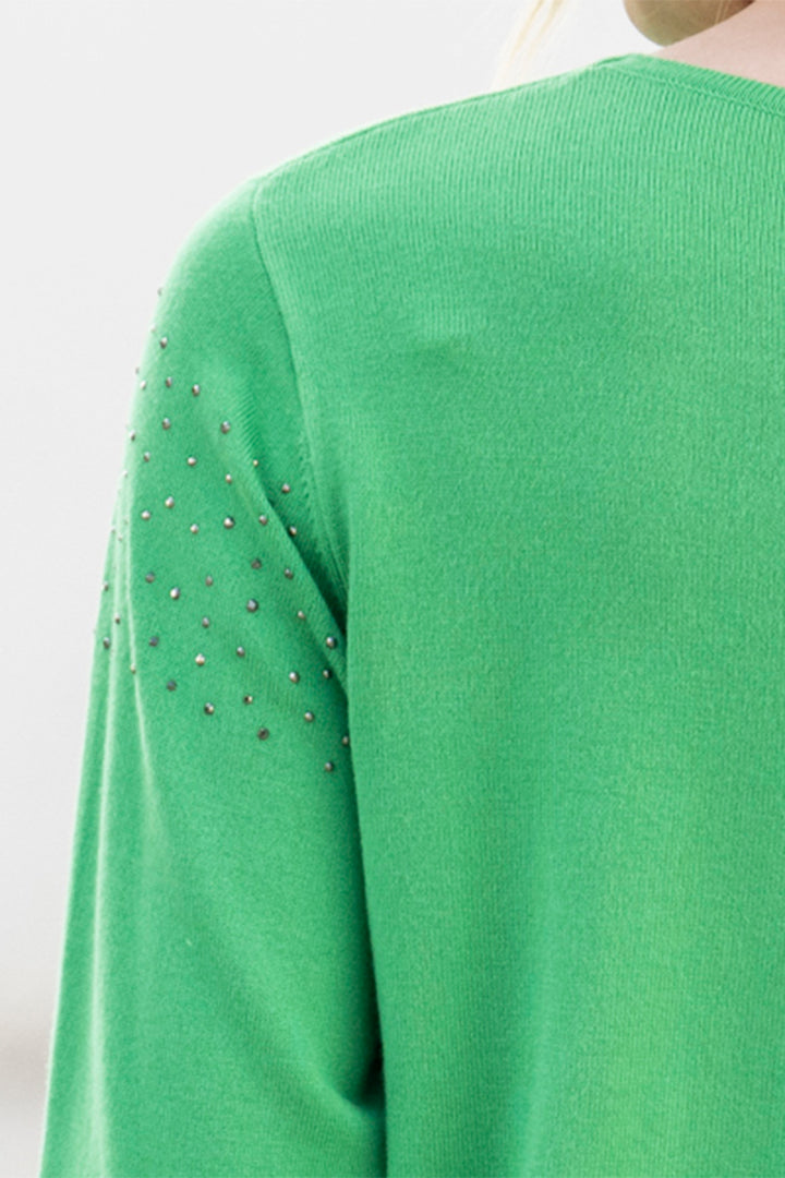 Green sweater with embellished sleeves on a white background