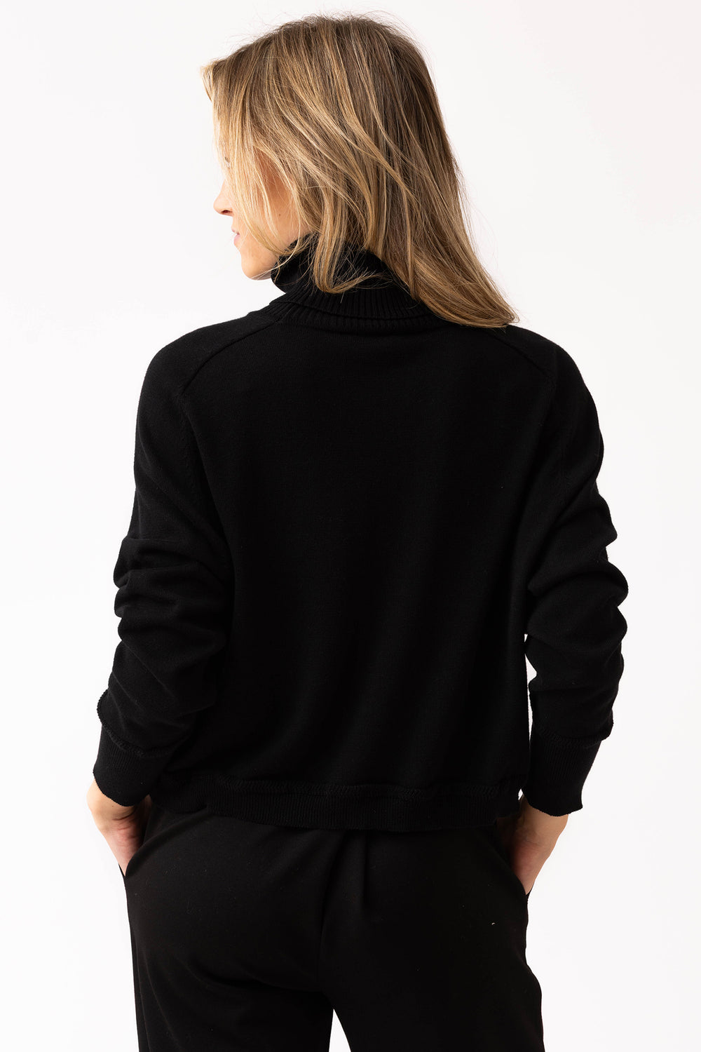 Person wearing a black outfit on a white background