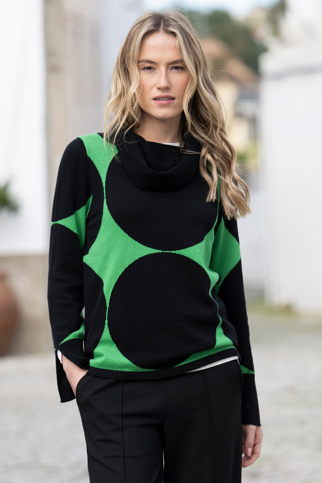Woman wearing a black and green patterned sweater outdoors
