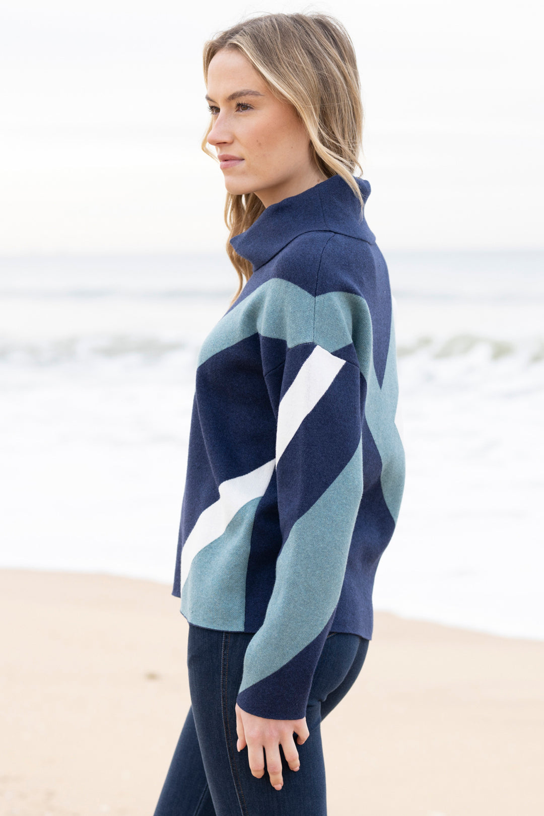 Woman wearing a blue and green striped sweater on a beach