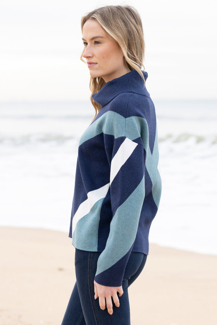 Woman wearing a blue and green striped sweater on a beach
