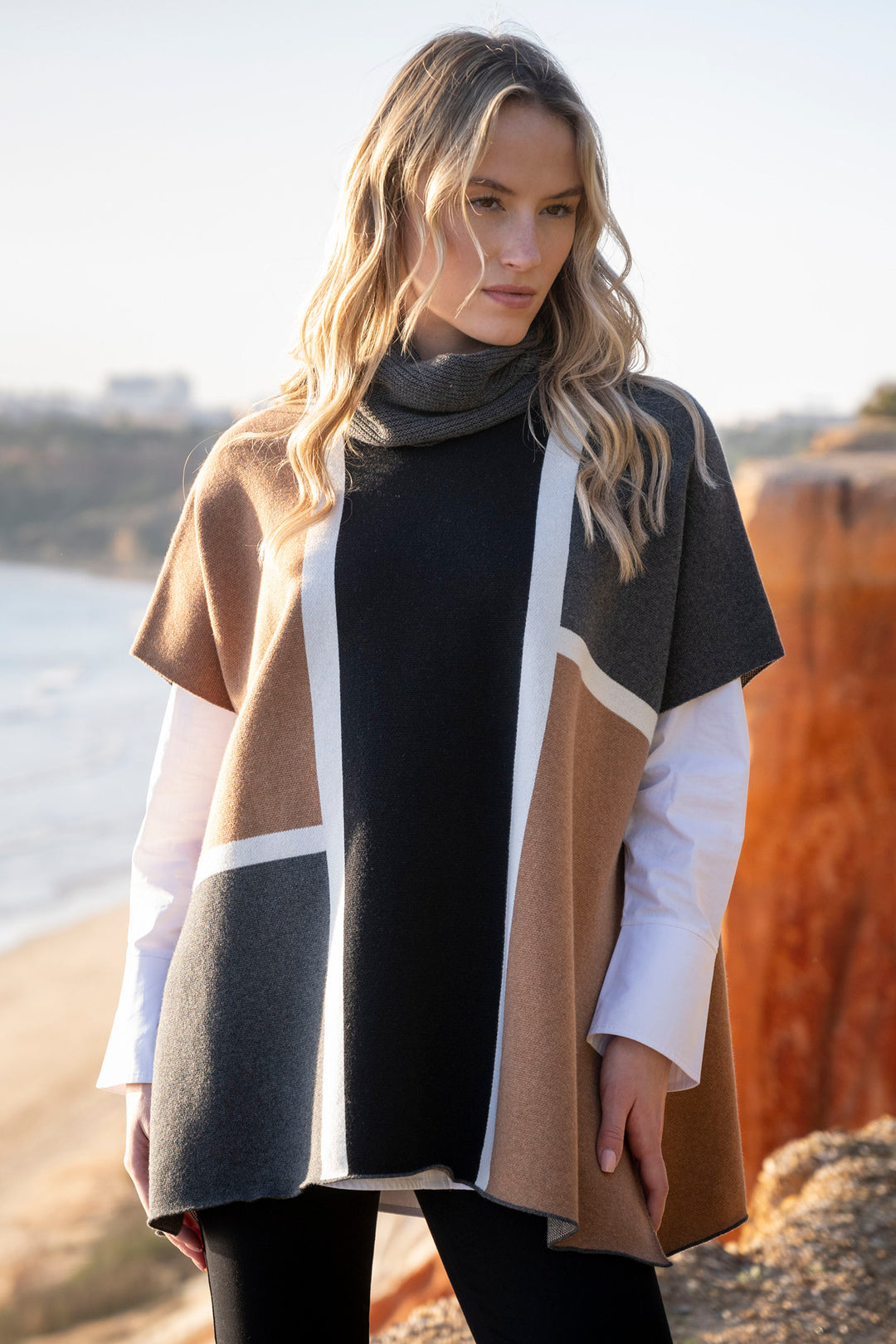 Woman wearing a patterned coat by a body of water