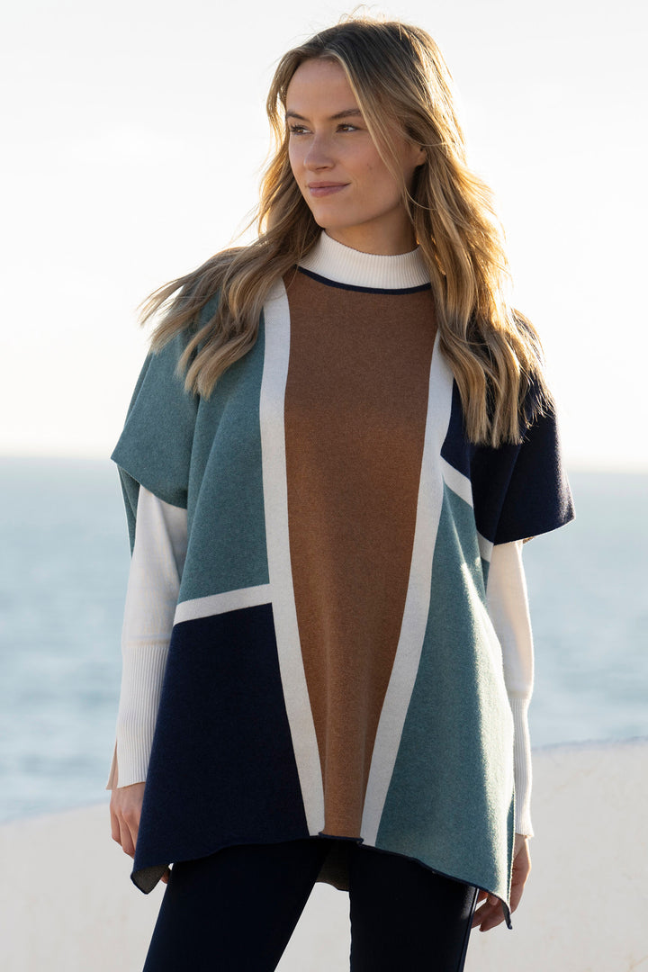 Woman wearing a colorful poncho with a beach background