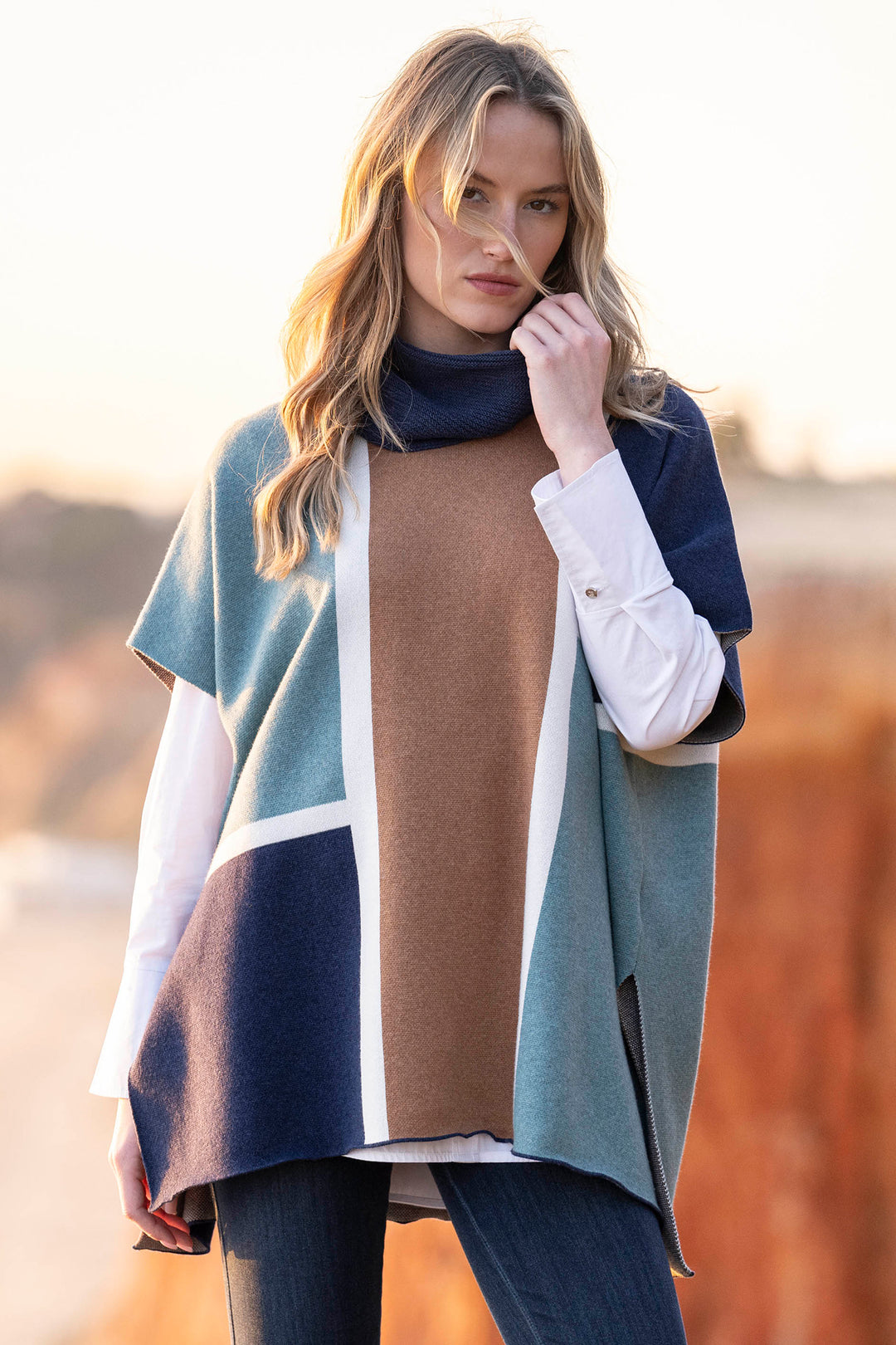Woman wearing a colorful poncho with a blurred natural background