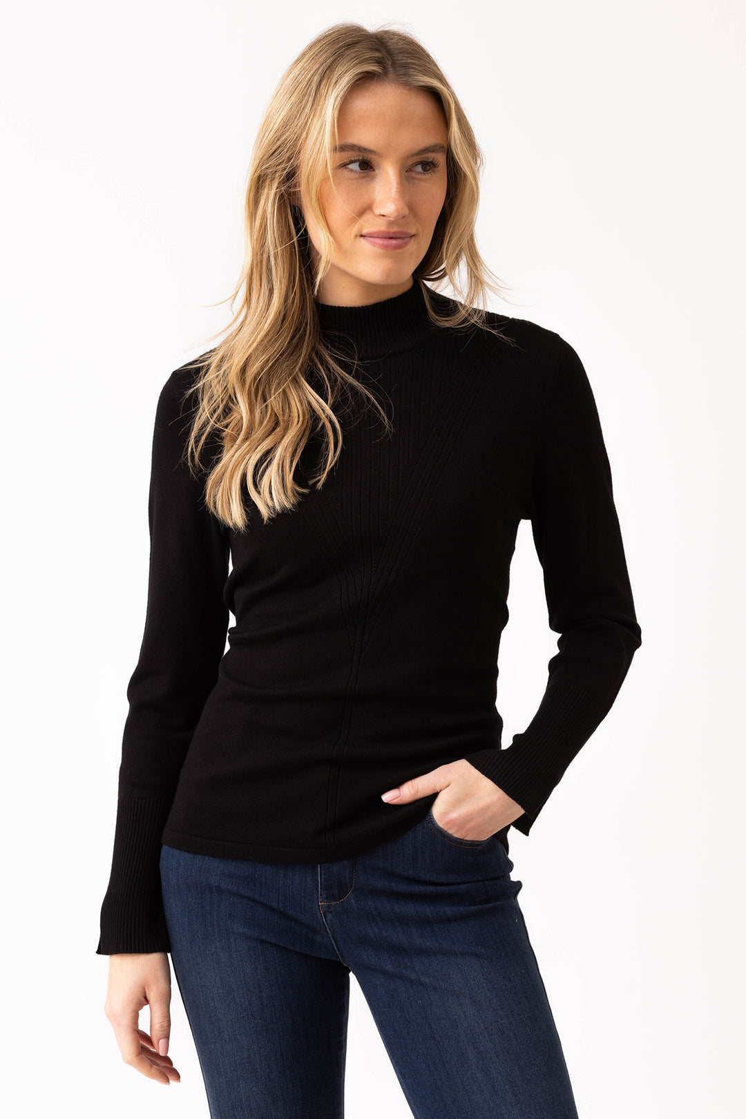 Woman wearing a black turtleneck sweater and blue jeans on a white background