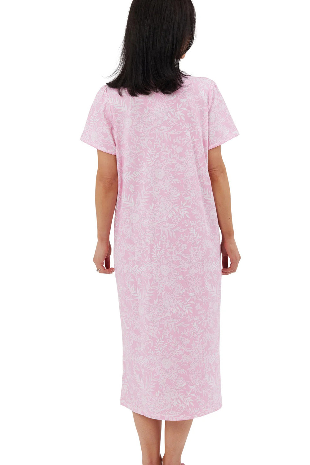Woman wearing a pink nightgown with a subtle pattern on a white background