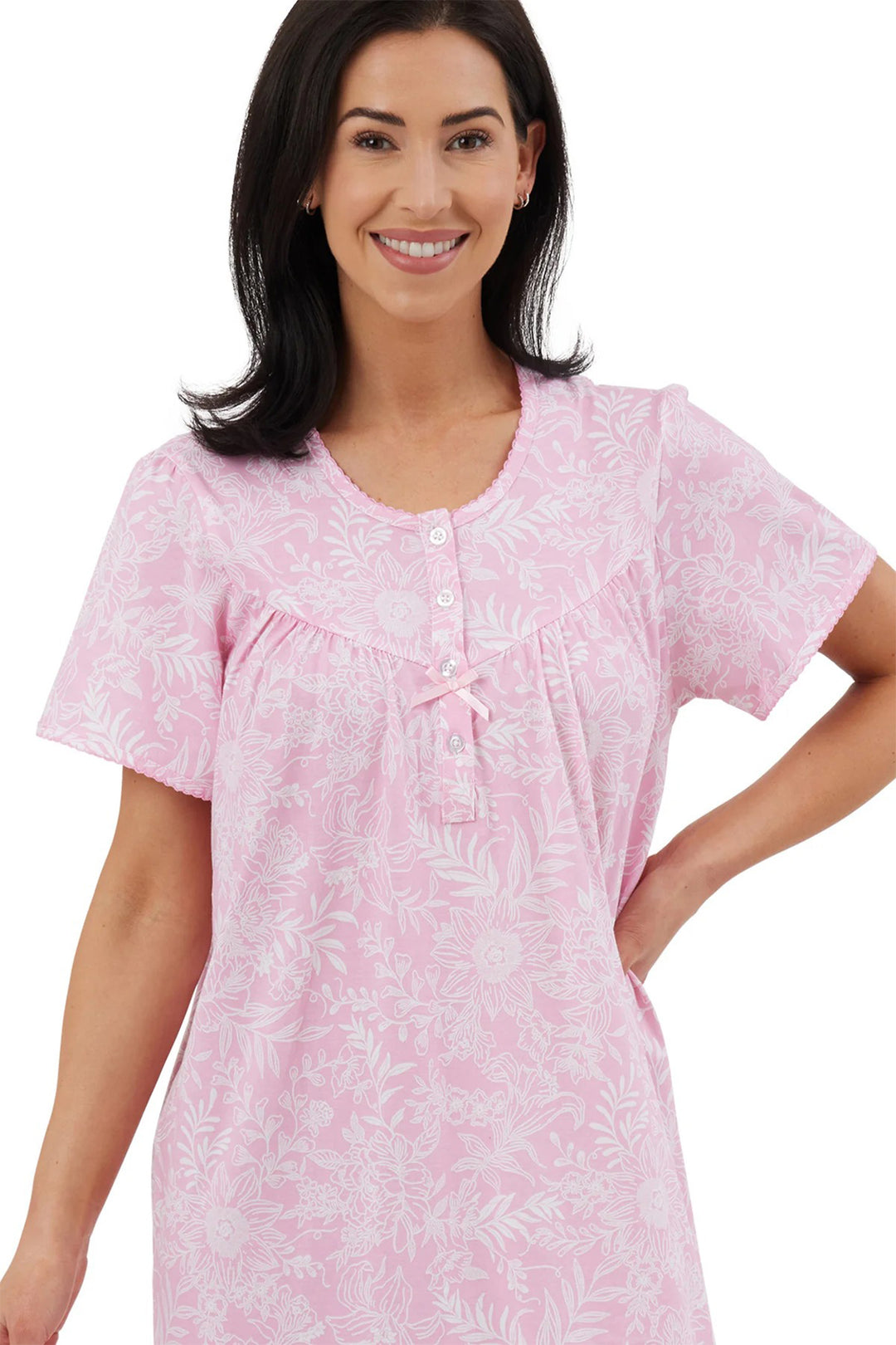Woman wearing a pink patterned nightshirt on a white background