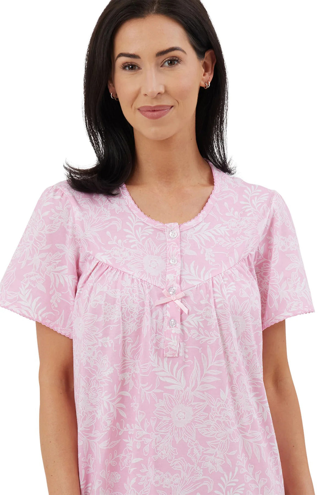 Woman wearing a pink floral nightshirt on a white background