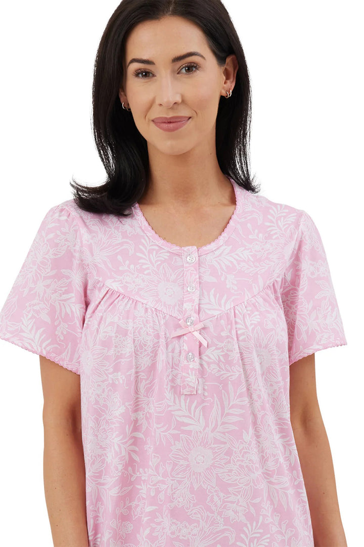 Woman wearing a pink floral nightshirt on a white background