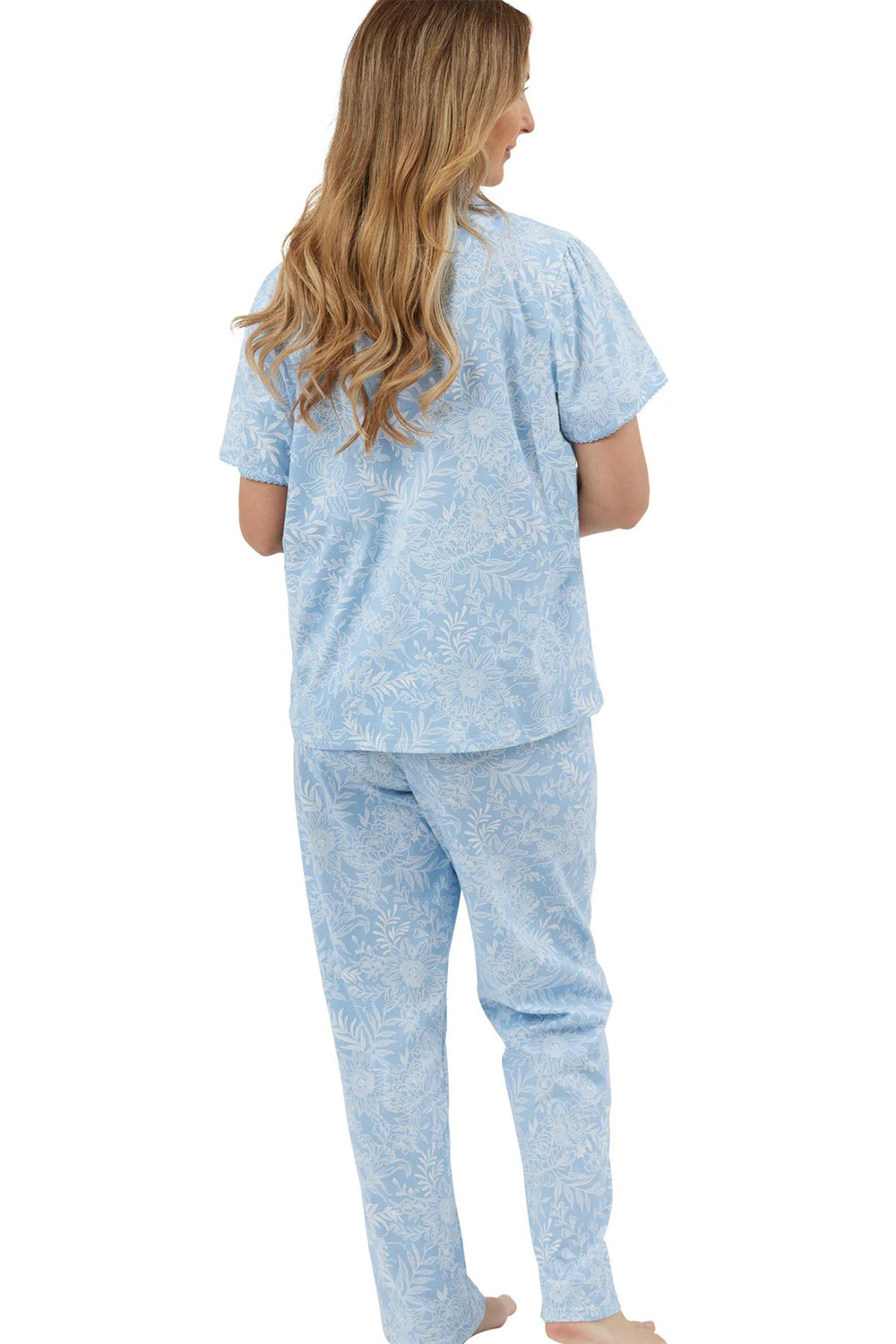 Woman wearing a light blue pajama set on a white background