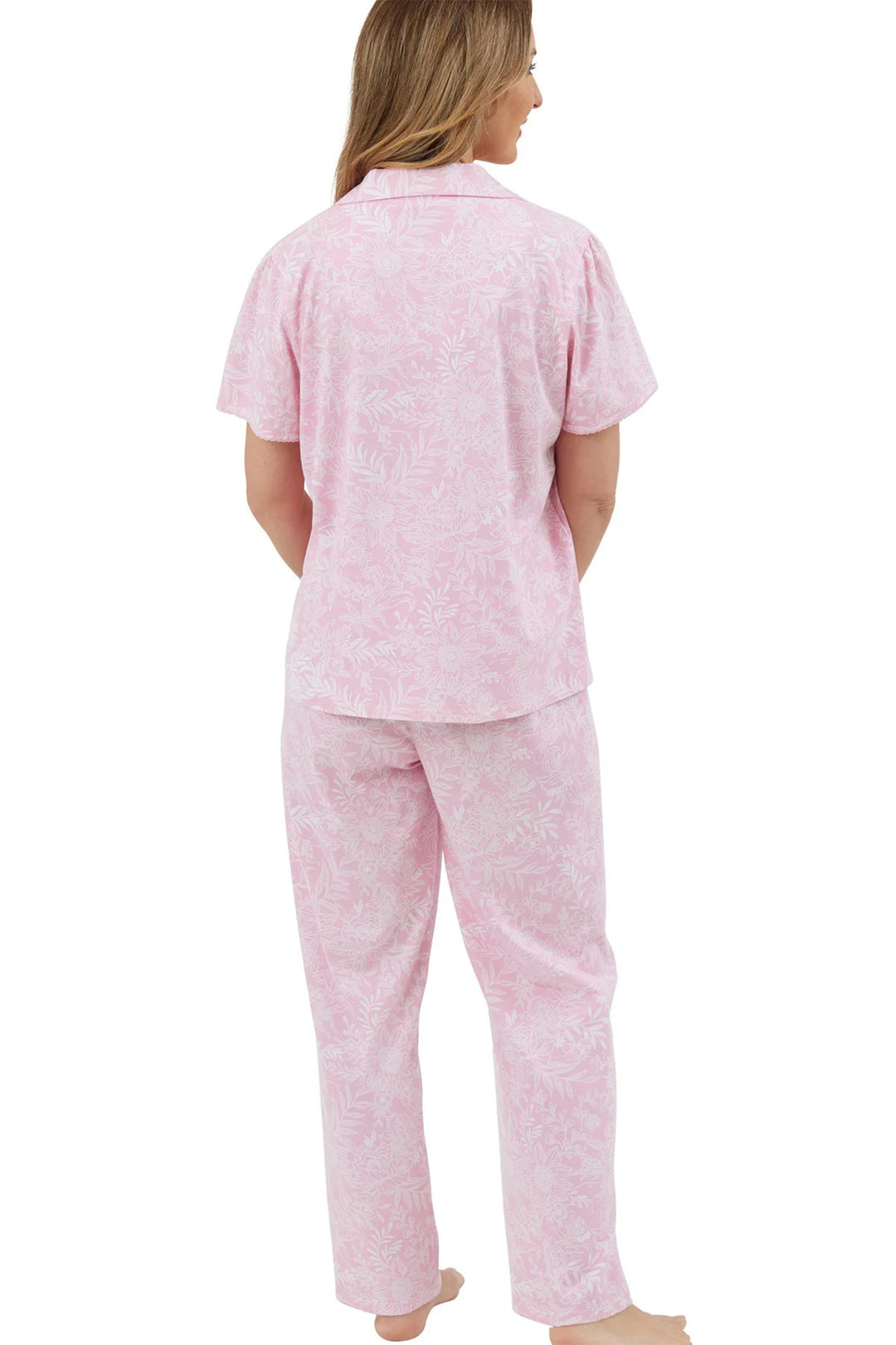 Woman wearing pink pajama set on a white background