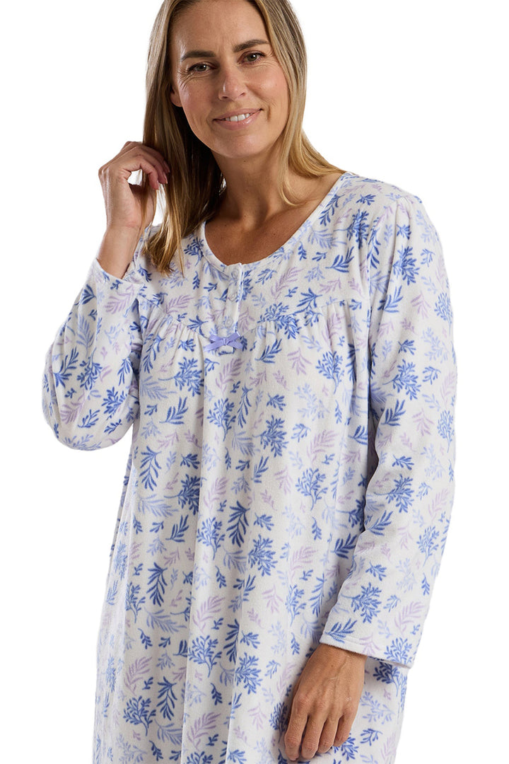 Woman wearing a long-sleeve floral patterned shirt on a white background