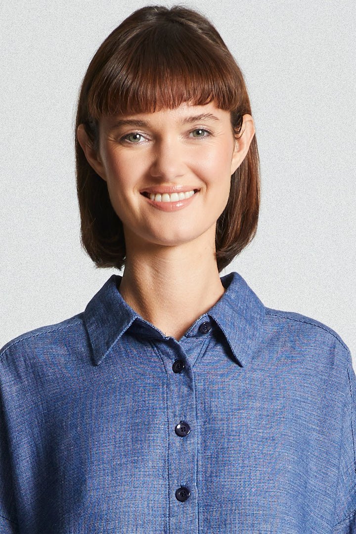 Woman wearing a blue shirt against a light gray background