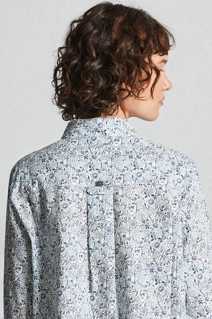 Person wearing a floral patterned shirt against a plain background