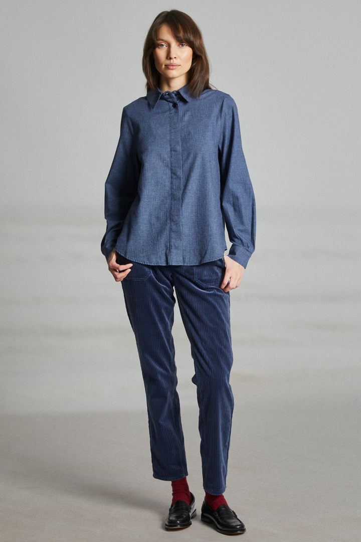 Person wearing a blue shirt and pants on a gray background