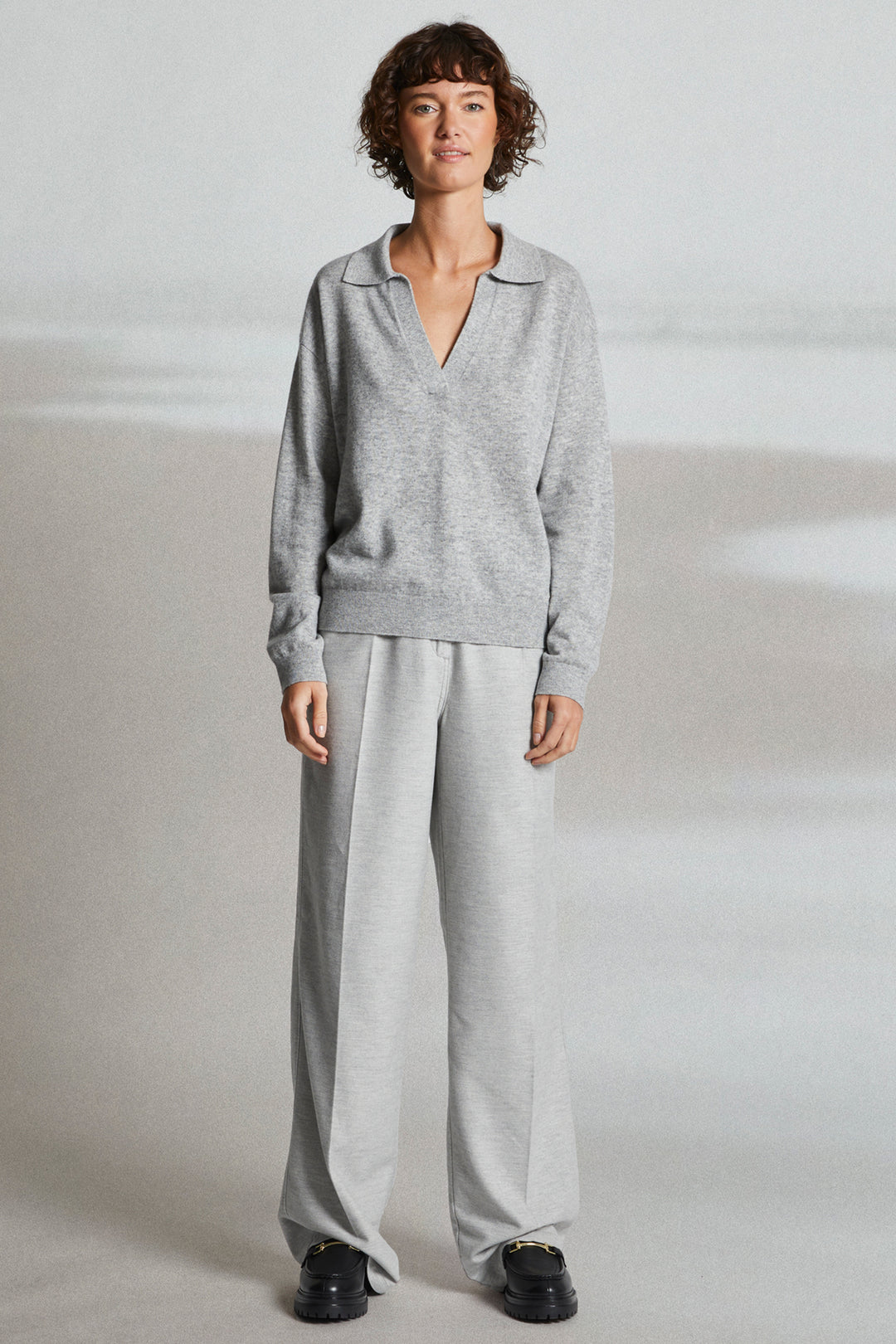Person wearing a gray outfit on a plain background