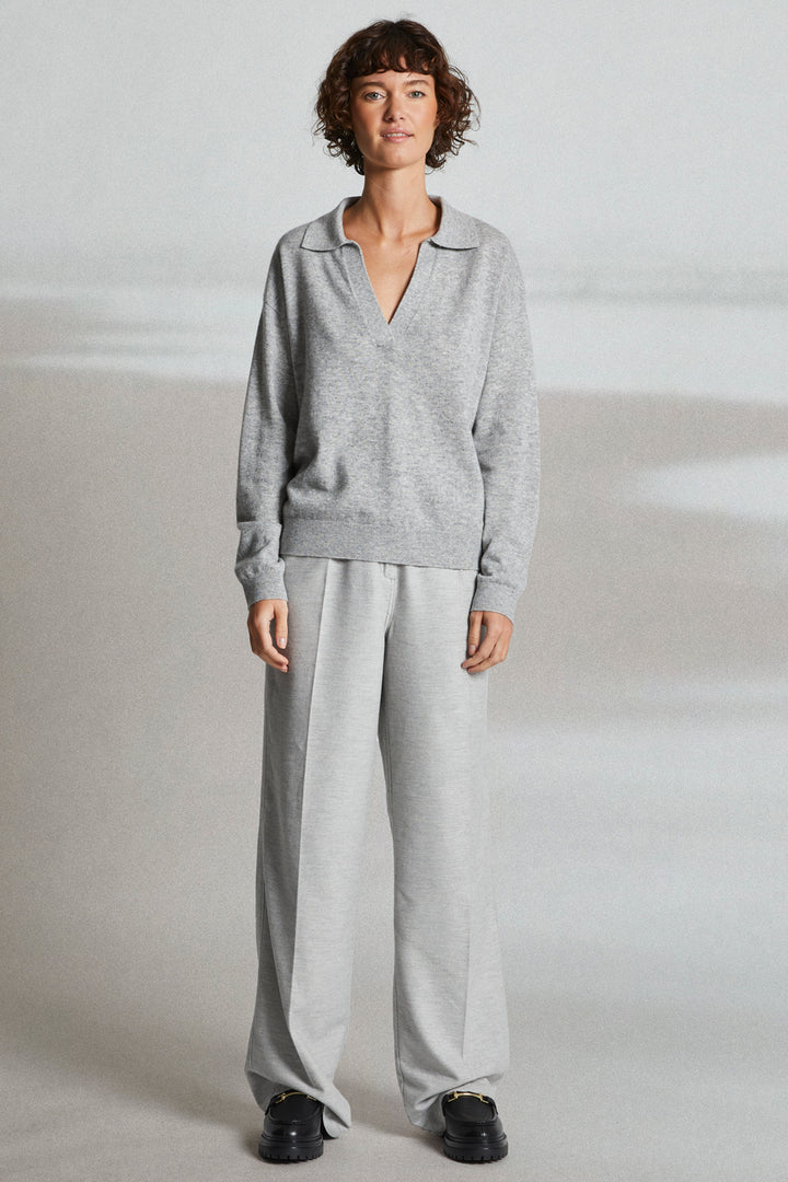 Person wearing a gray outfit on a plain background