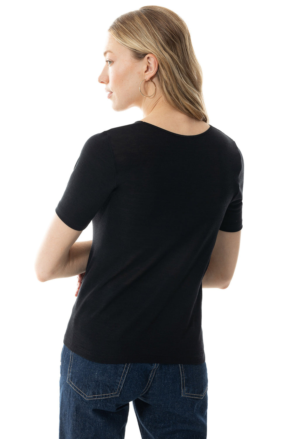 Person wearing a black t-shirt and blue jeans on a white background