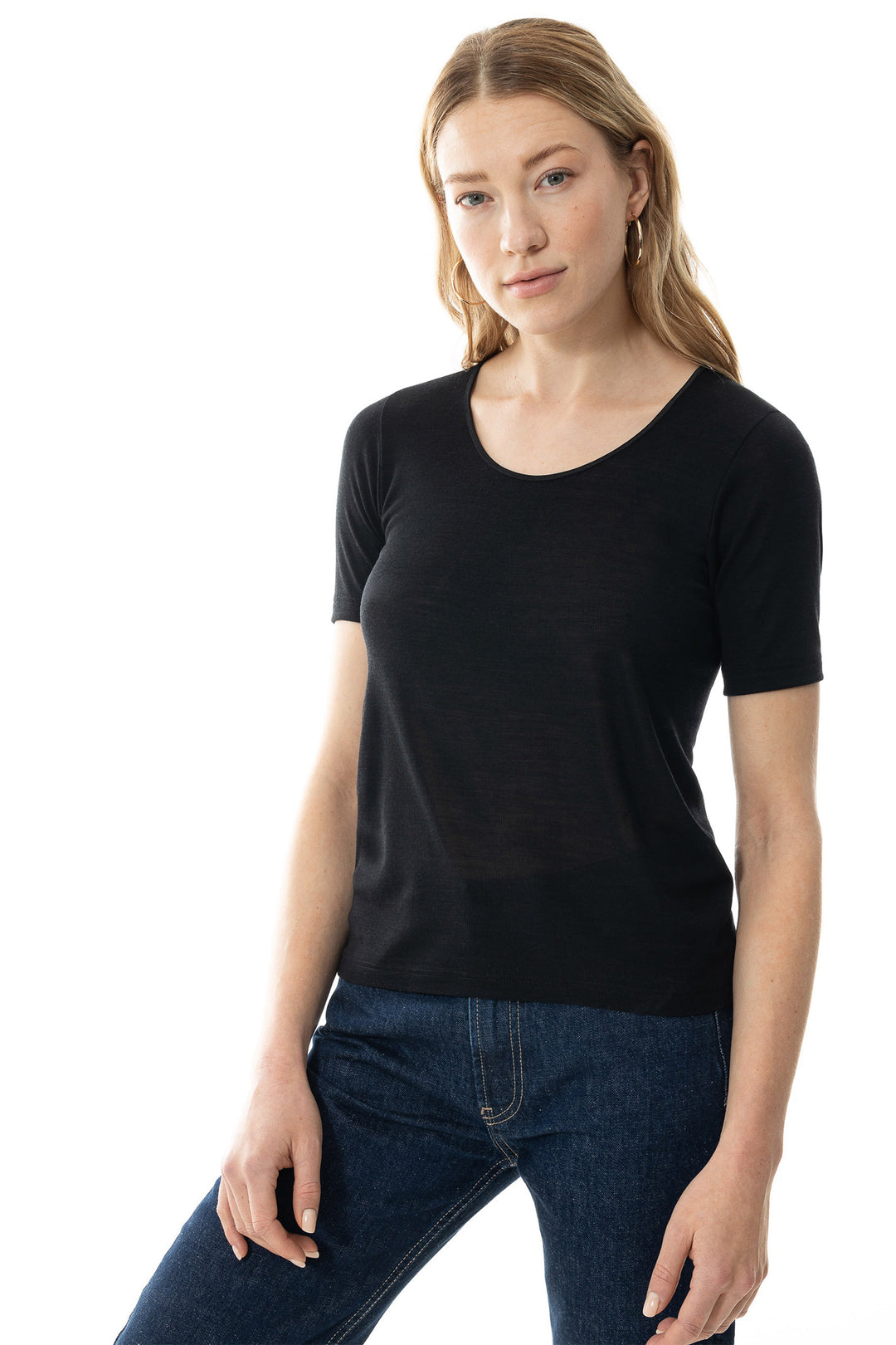 Woman wearing a black t-shirt and blue jeans on a white background