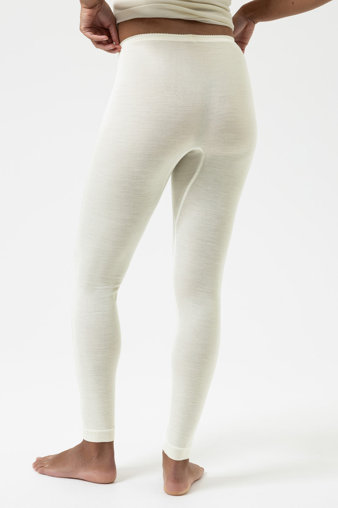 White leggings worn by a person on a white background