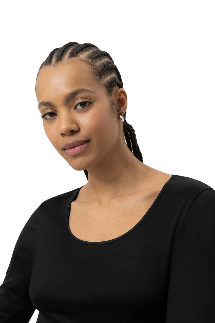 Woman with braided hair wearing a black top on a white background