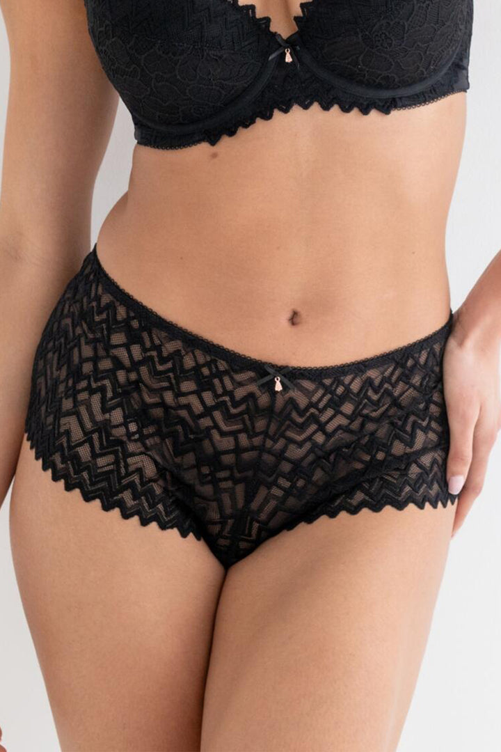 Person wearing black lace lingerie on a plain background