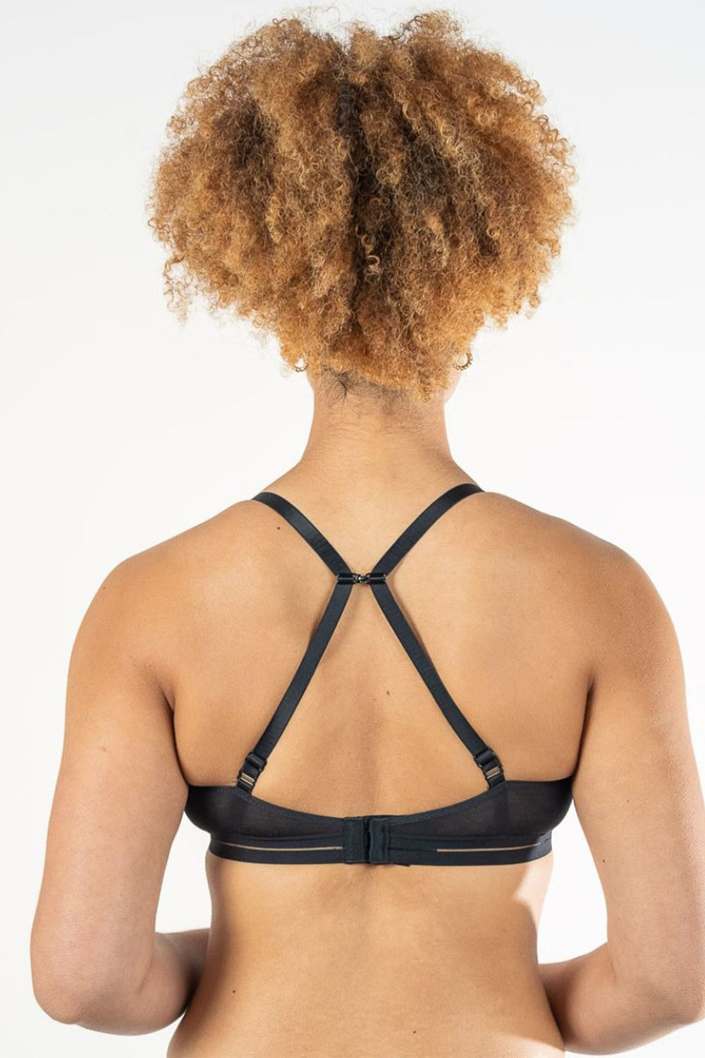 Person wearing a black strappy top on a white background