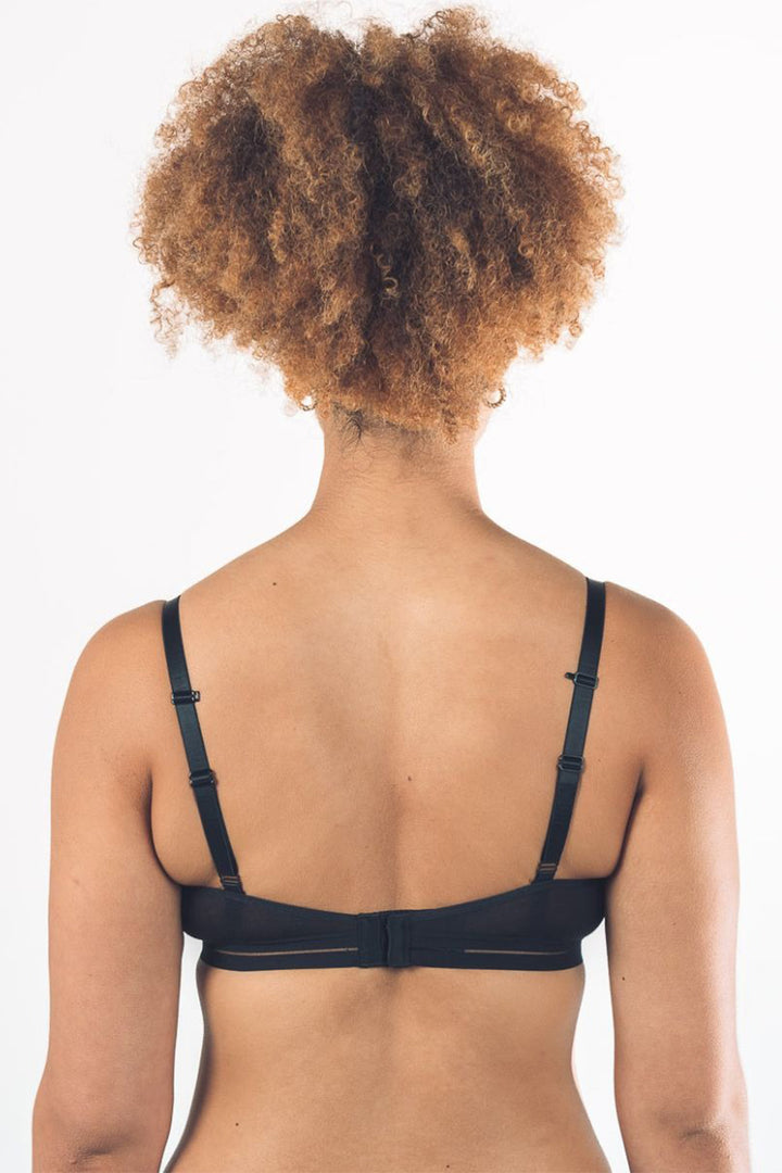 Person wearing a black bralette on a white background