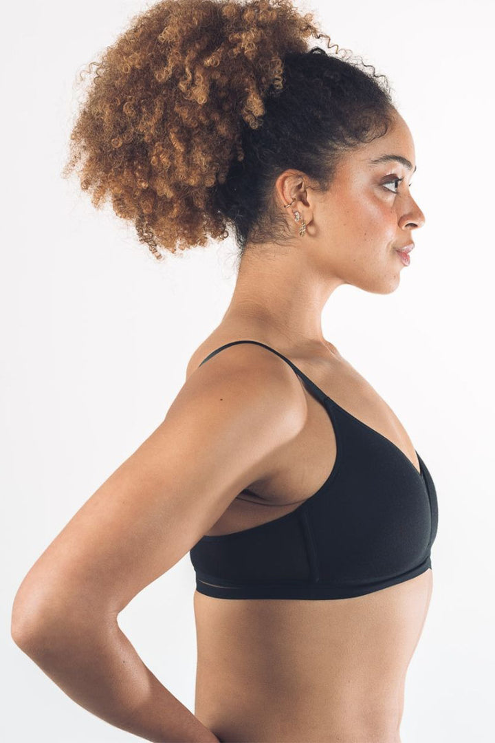 Woman wearing a black sports bra against a white background