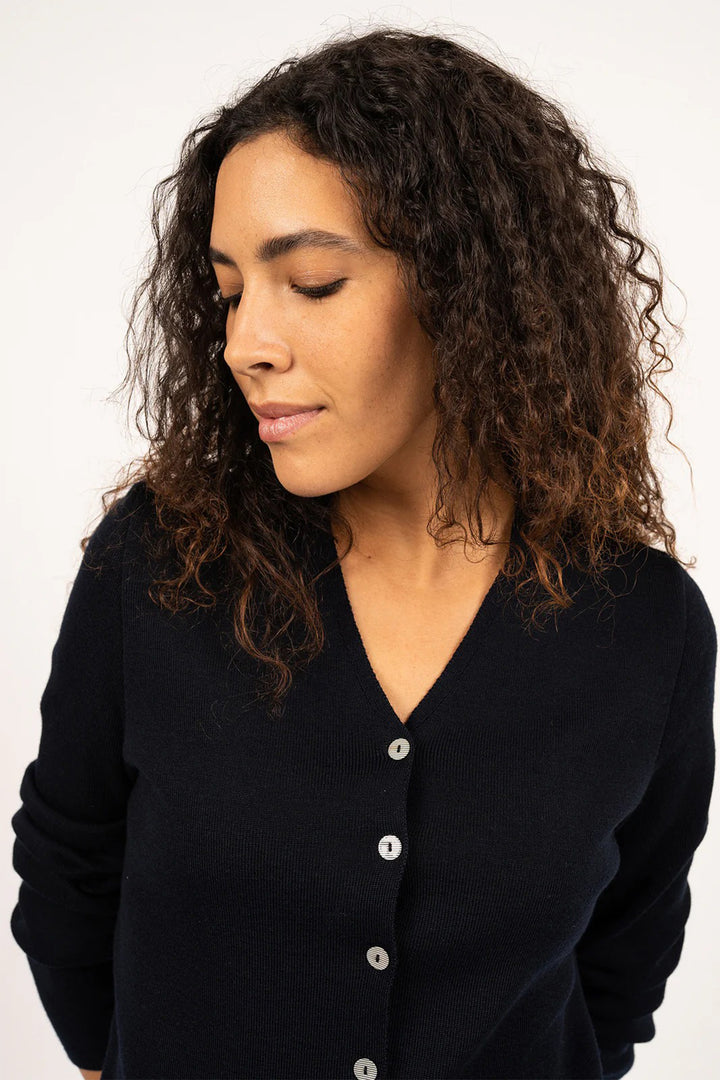 Woman wearing a navy cardigan against a white background
