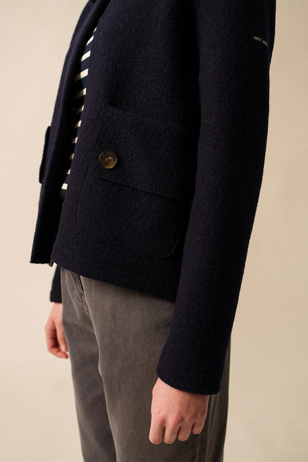 Navy blazer with a button on a beige background