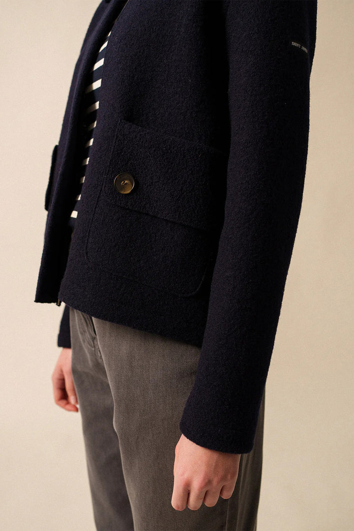 Navy blazer with a button on a beige background