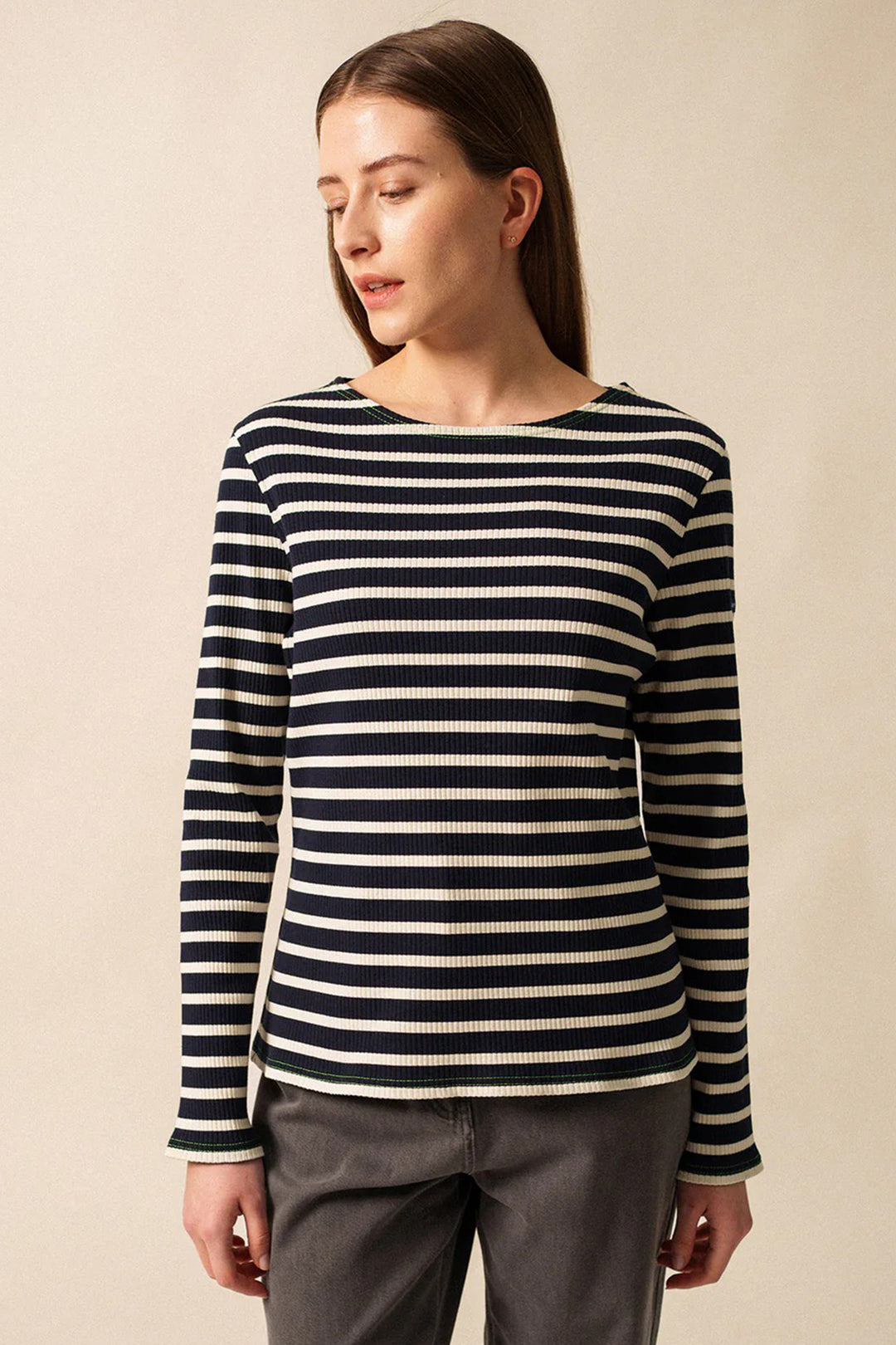 Woman wearing a black and white striped sweater against a beige background