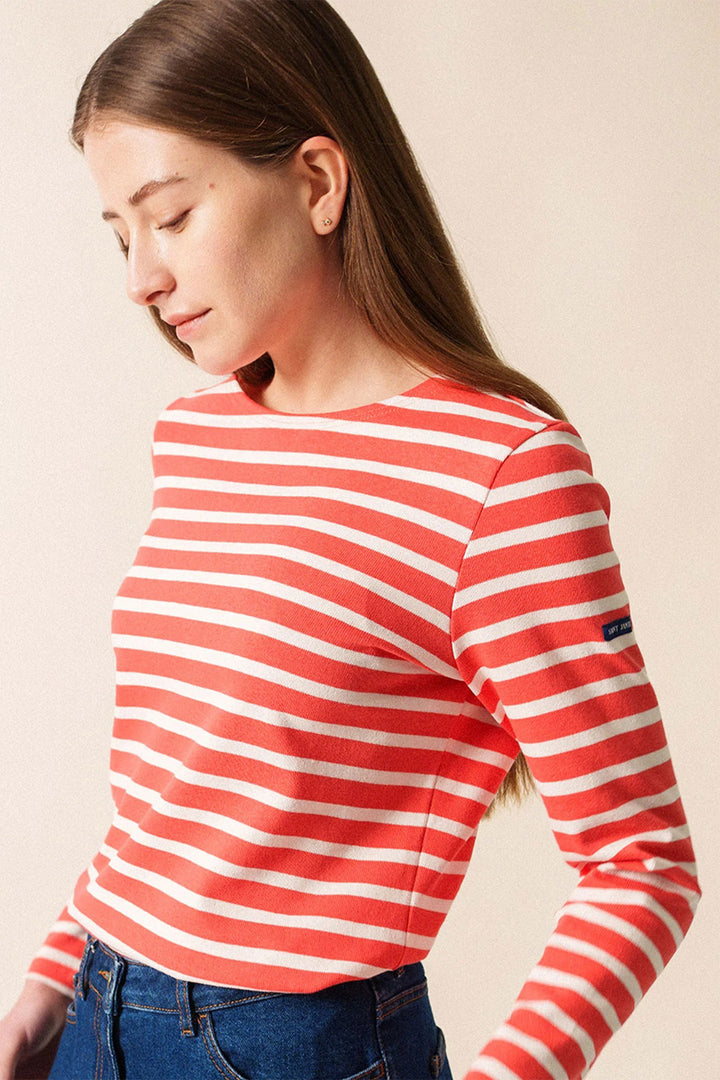 Woman wearing a red and white striped long-sleeve shirt against a beige background