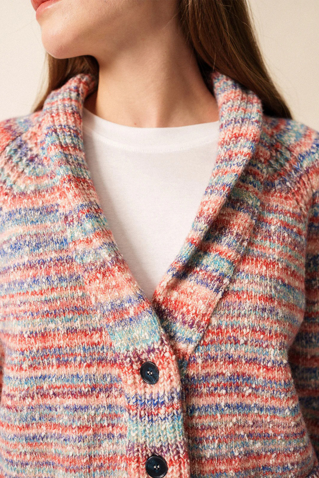 Close-up of a multicolored textured coat with a white shirt underneath.