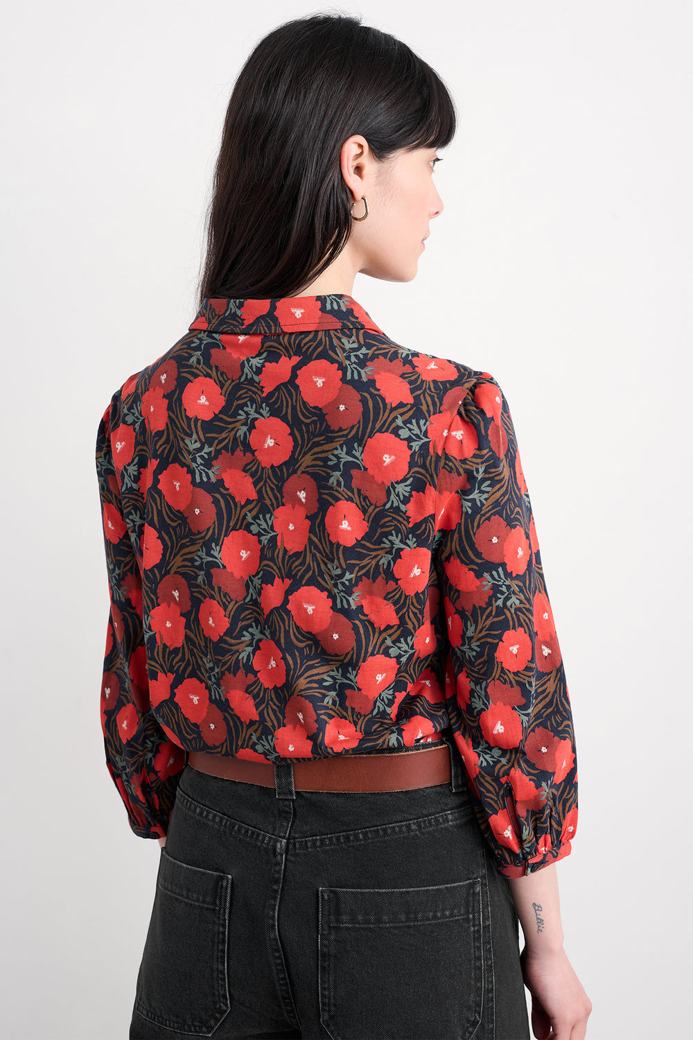 Person wearing a red floral patterned shirt on a white background