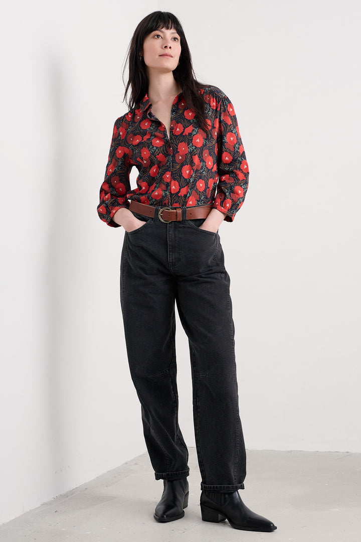 Person wearing a floral jacket and black pants on a white background