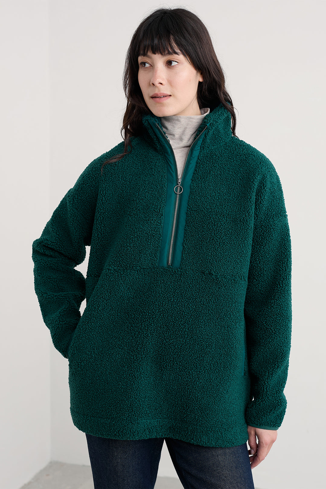 Person wearing a green fleece pullover against a white background