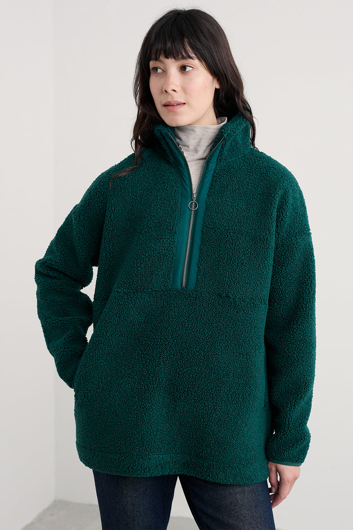 Person wearing a green fleece pullover against a white background