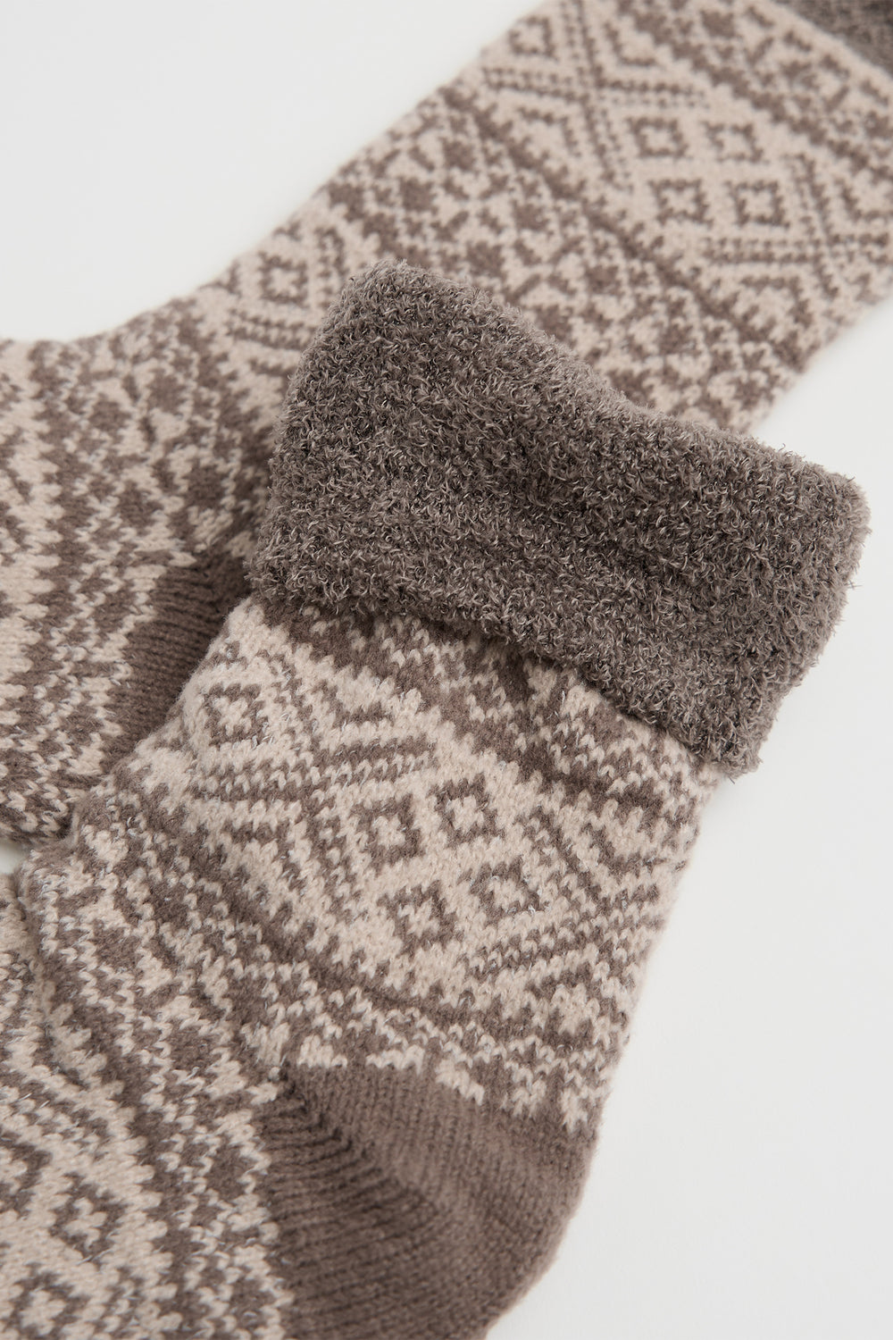 Pair of patterned socks with fuzzy trim on a light background