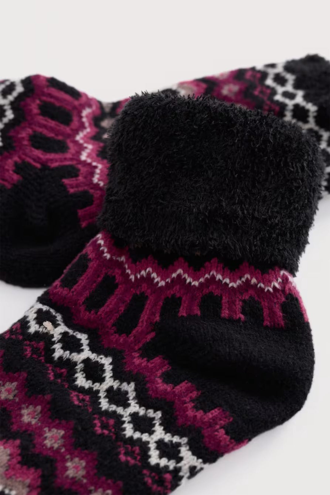 Pair of black socks with pink and white pattern on a white background