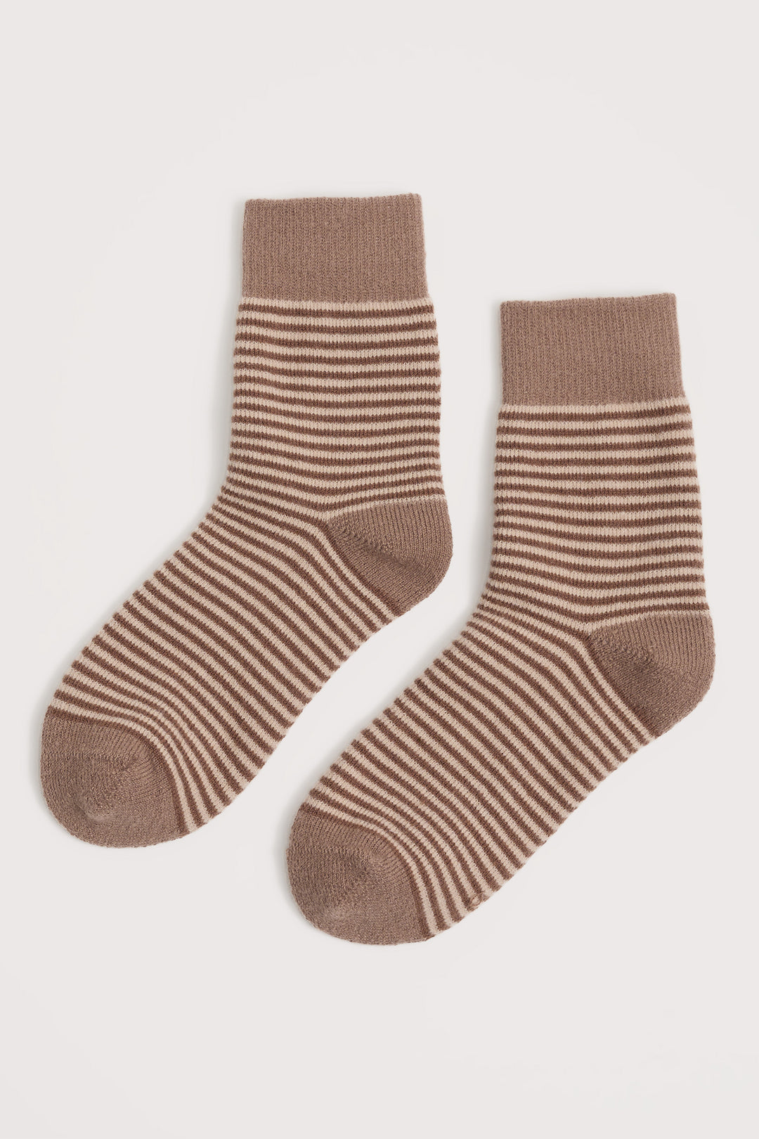 Pair of brown striped socks on a light beige background
