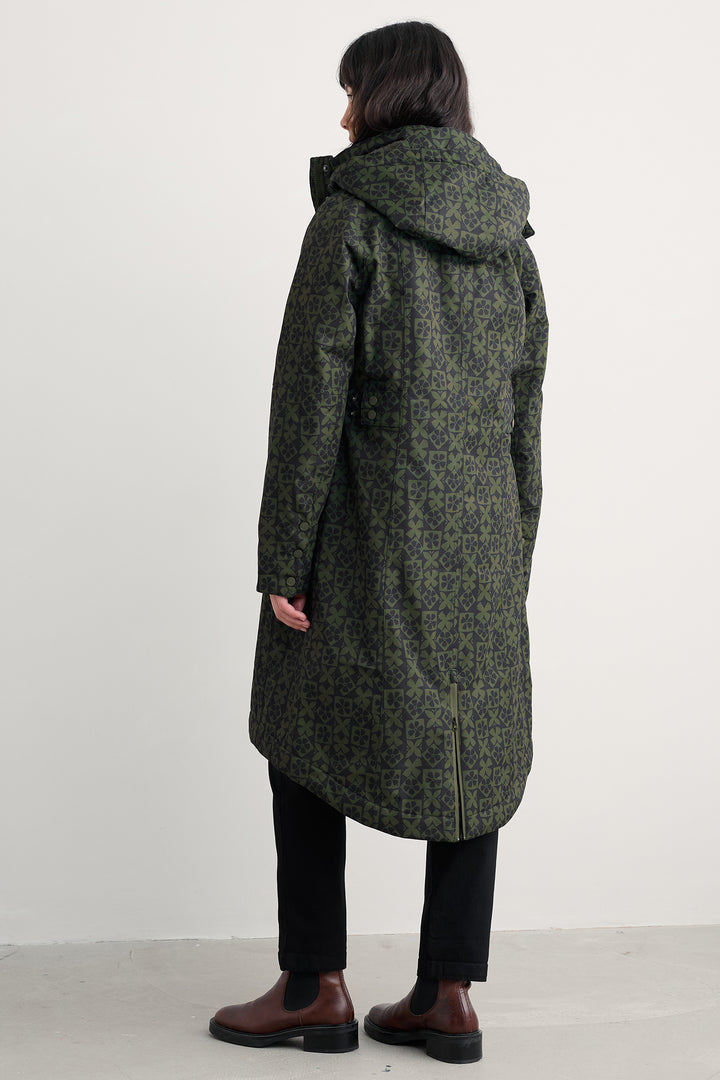 Person wearing a long green coat with a hood on a white background