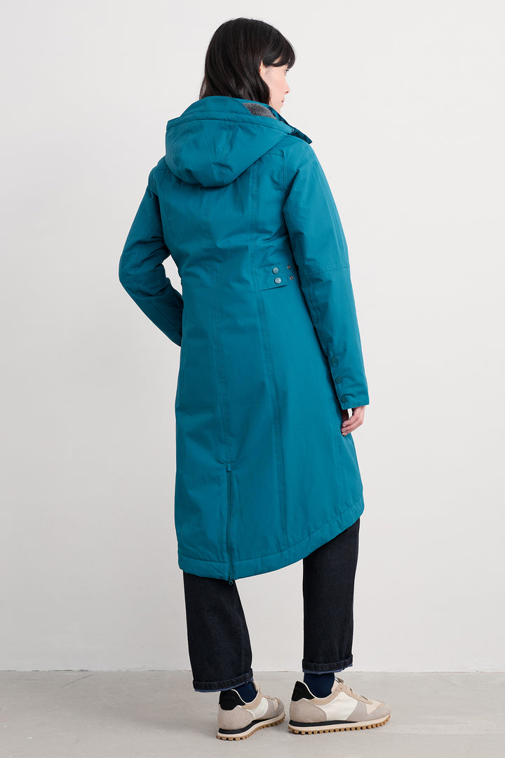 Person wearing a teal coat on a white background