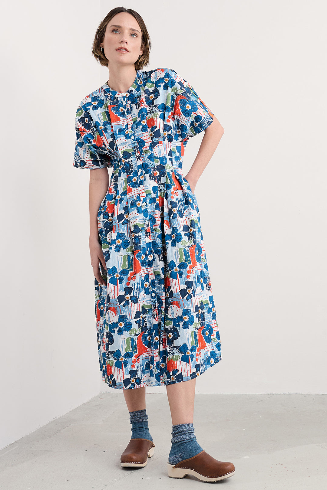 Woman wearing a colorful floral dress on a white background